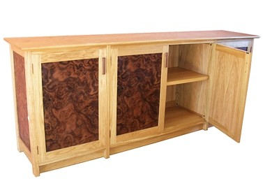 An oak and walnut sideboard with one door open